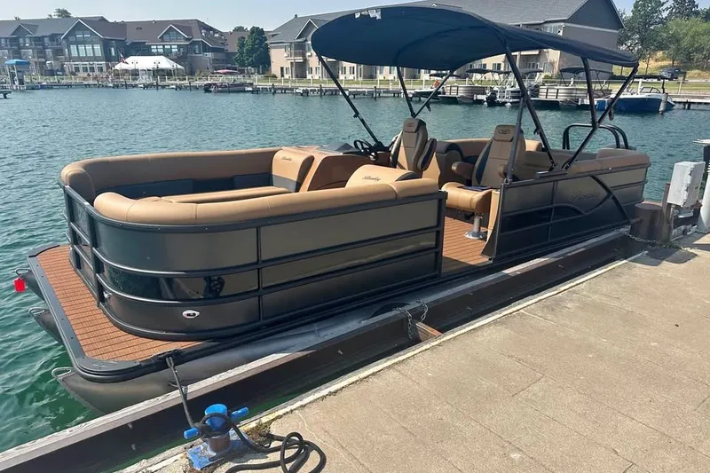 The Image of 2026 Bentley Pontoons Legacy 243 Navigator docked by waterfront homes. - 0