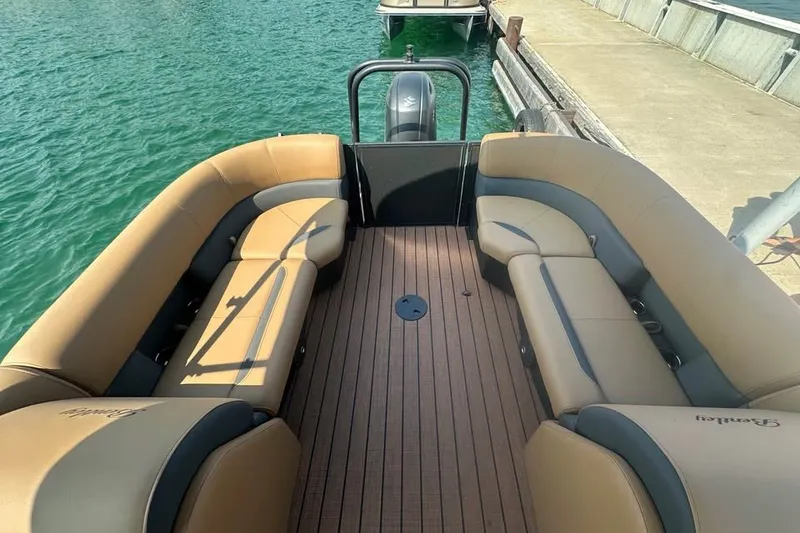 Slide: The Image of 2026 Bentley Pontoons Legacy 243 Navigator with tan seating, docked on clear water. - 5