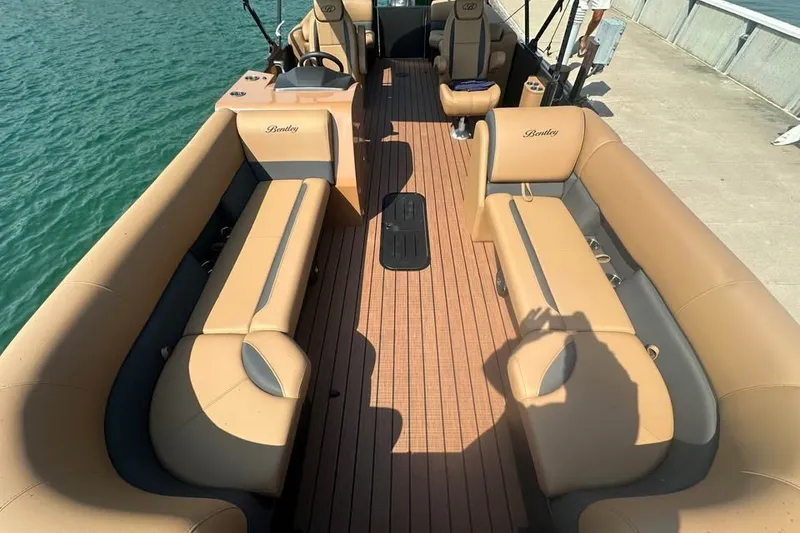 Slide: The Image of 2026 Bentley Pontoons Legacy 243 Navigator interior with tan seating and wood flooring. - 8