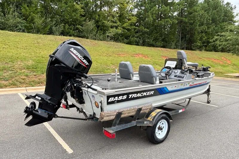 Slide: The Image of 1994 Tracker Tournament V-17 bass boat with Mercury outboard motor in a parking lot. - 16