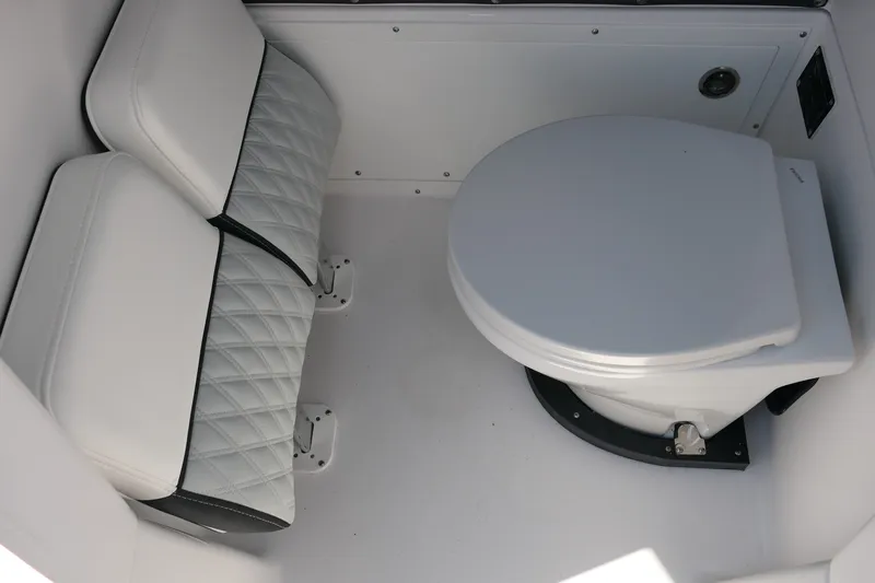 Slide: The Image of 2027 Blackfin 262 HB boat interior with white cushioned seating and marine toilet. - 16