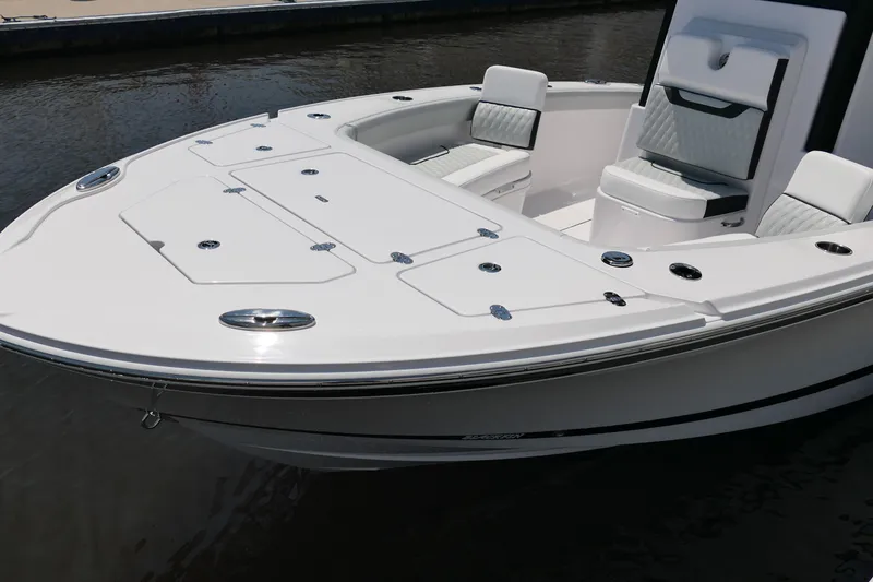 Slide: The Image of 2027 Blackfin 262 HB boat with sleek white deck and seating, docked on calm water. - 18