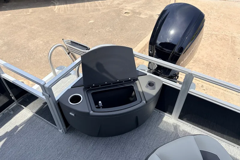 Slide: The Image of 2027 Sun Tracker Bass Buggy 18 DLX pontoon boat with open storage compartment and outboard motor. - 31
