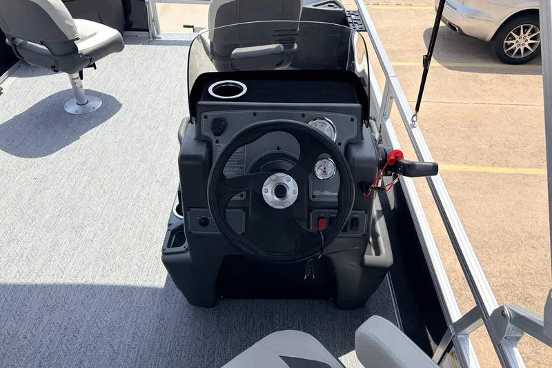 Slide: The Image of 2027 Sun Tracker Bass Buggy 18 DLX steering console with gauges and seating. - 23