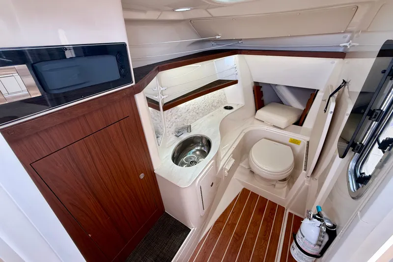 Slide: The Image of 2018 Grady-White Freedom 325 boat interior with sink, toilet, and wood accents. - 16