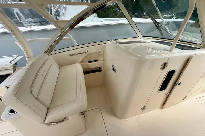 Slide: The Image of 2018 Grady-White Freedom 325 boat interior with cushioned seating and helm station. - 14