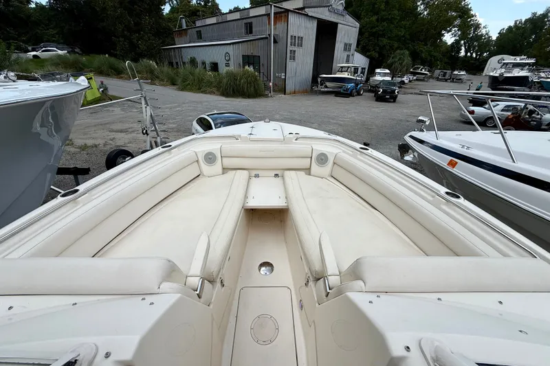 Slide: The Image of 2018 Grady-White Freedom 325 boat with spacious seating, docked near a rustic building. - 13
