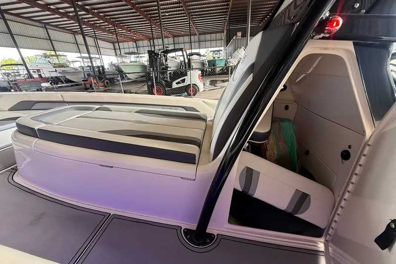 Slide: The Image of 2020 ShearWater 270 Carolina Flare boat interior with seating and storage in a covered marina. - 31