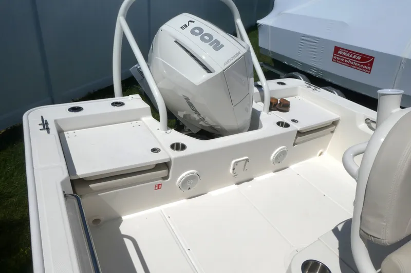 Slide: The Image of 2027 Boston Whaler 210 Montauk boat interior with Mercury engine, showcasing seating and storage. - 4