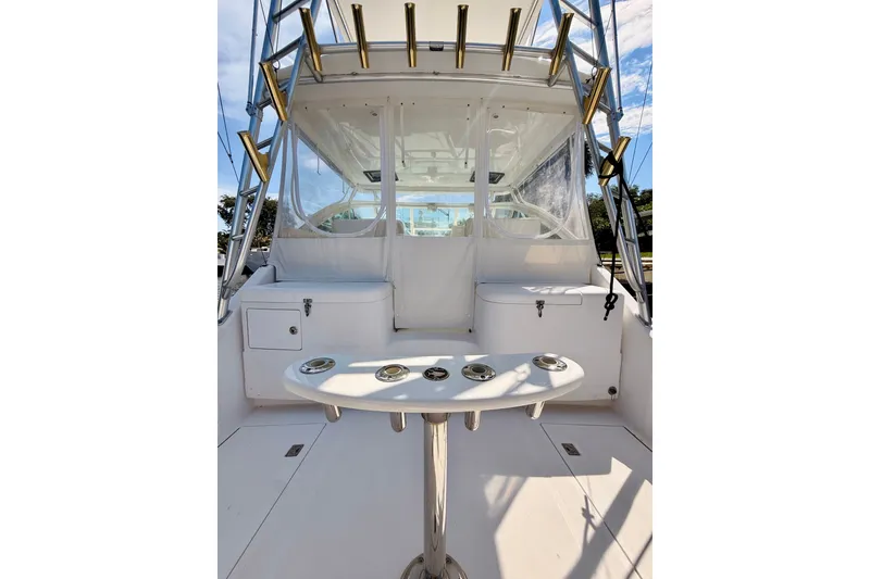 Slide: The Image of 2004 Cabo 35 Express boat interior with fishing rod holders and seating area. - 8