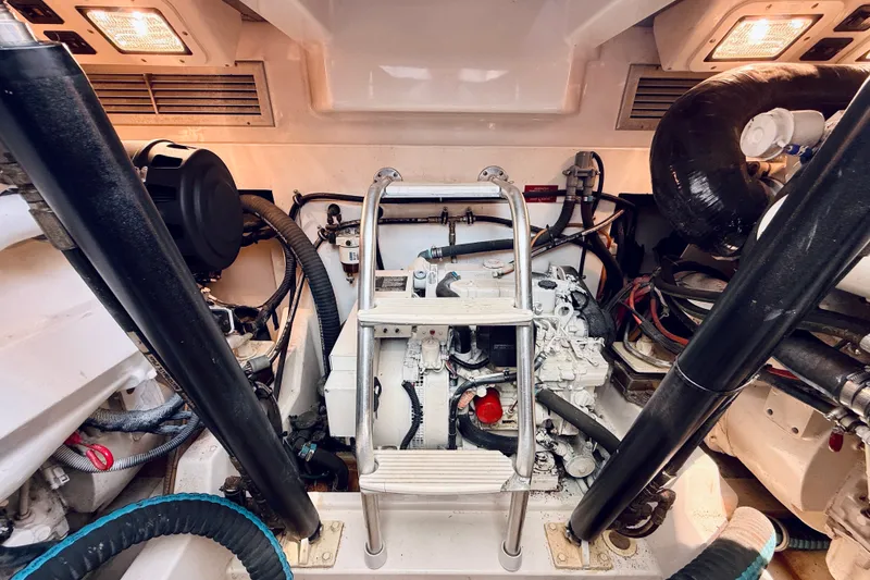 Slide: The Image of Engine room of a 2004 Cabo 35 Express boat with visible machinery and ladder. - 35