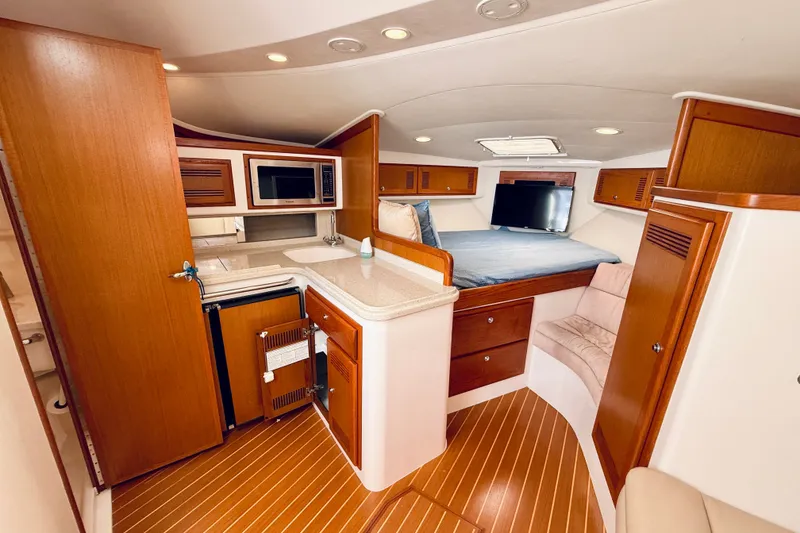 Slide: The Image of Luxurious interior of 2004 Cabo 35 Express yacht with kitchenette and cozy sleeping area. - 18