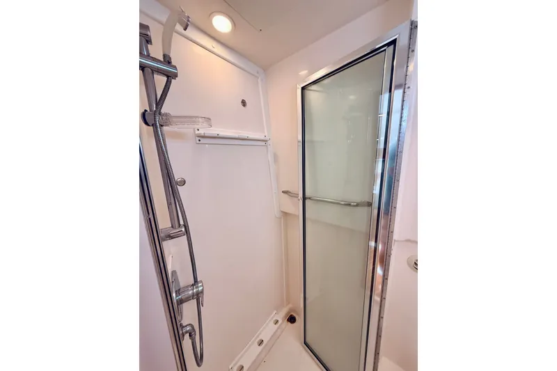 Slide: The Image of Shower area in 2004 Cabo 35 Express boat with glass door and chrome fixtures. - 27