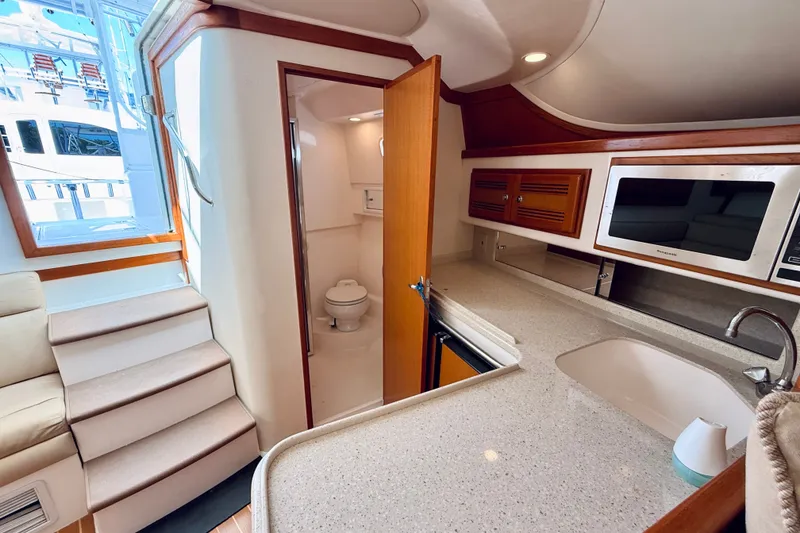 Slide: The Image of Interior of 2004 Cabo 35 Express yacht with kitchenette and bathroom. - 21