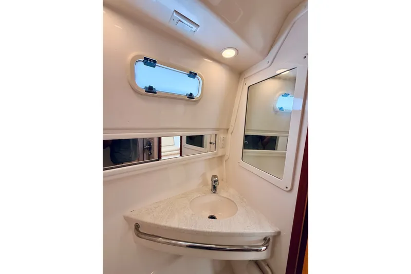 Slide: The Image of Compact bathroom interior of 2004 Cabo 35 Express boat with sink and mirror. - 26