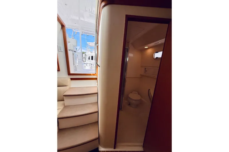 Slide: The Image of Interior view of 2004 Cabo 35 Express yacht, featuring stairs and a compact bathroom. - 24