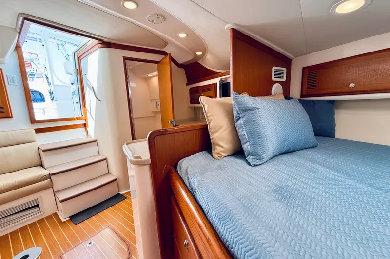 Slide: The Image of Interior of 2004 Cabo 35 Express yacht with cozy bed and wooden accents. - 20