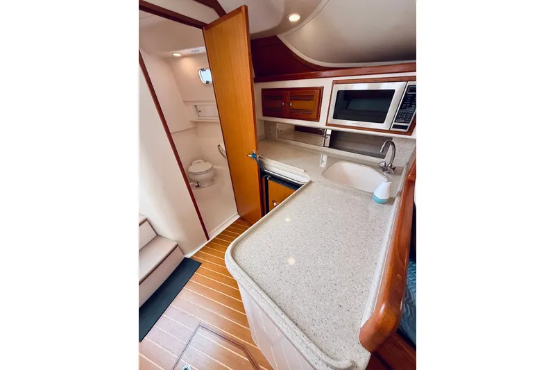 Slide: The Image of 2004 Cabo 35 Express yacht interior with kitchenette and bathroom. - 22