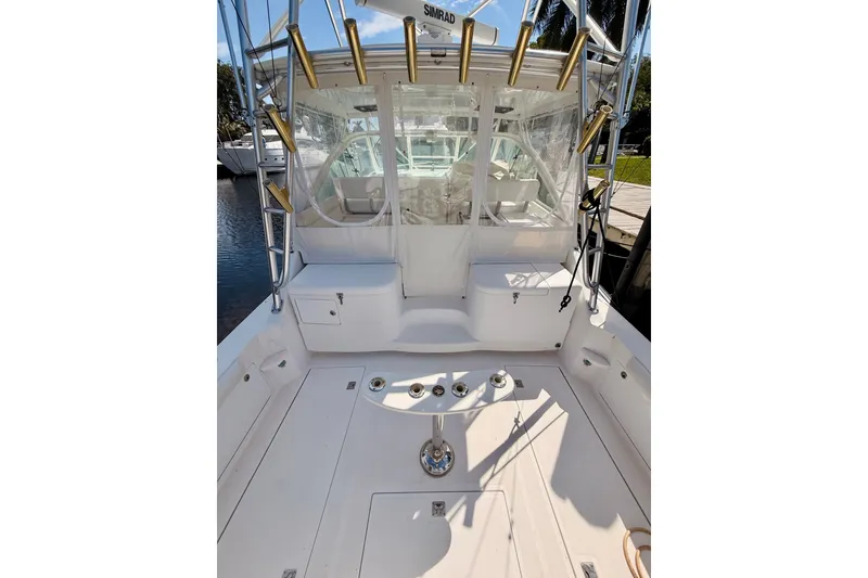 Slide: The Image of 2004 Cabo 35 Express boat deck with fishing rod holders and seating area. - 7
