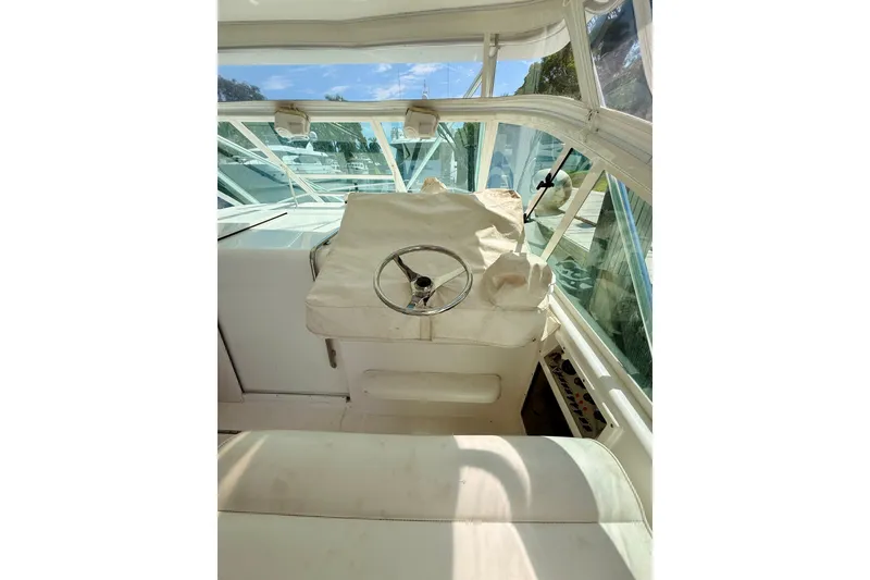 Slide: The Image of Interior helm of 2004 Cabo 35 Express boat with covered steering wheel. - 13