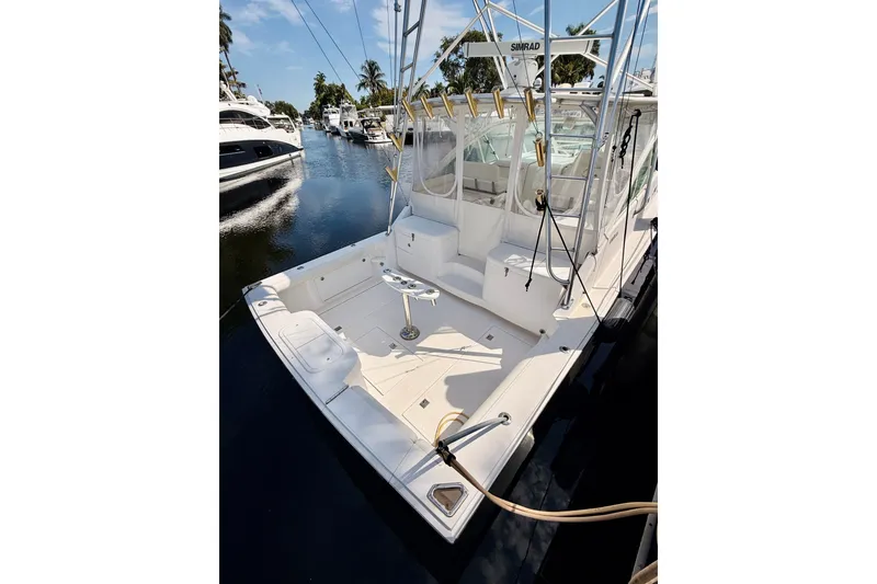 Slide: The Image of 2004 Cabo 35 Express boat docked, featuring spacious deck and fishing equipment. - 5