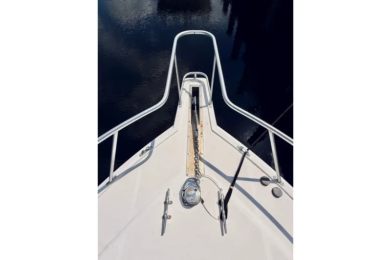 Slide: The Image of Bow view of 2004 Cabo 35 Express boat with anchor chain and railing. - 39