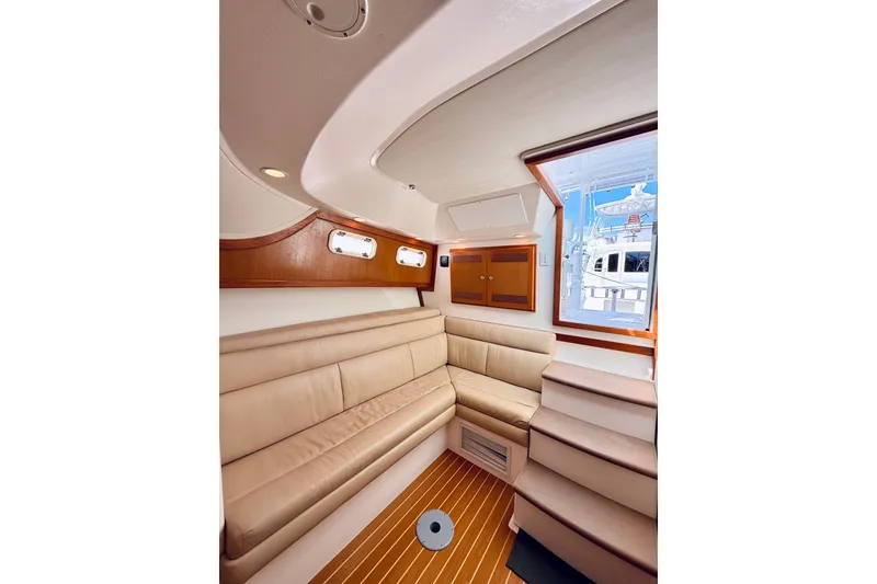 Slide: The Image of Interior of 2004 Cabo 35 Express yacht with beige seating and wooden accents. - 23