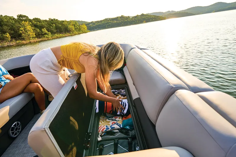 Slide: The Image of Manufacturer Provided Image: Woman organizing storage on 2026 Sun Tracker Party Barge 22 XP3, scenic lake view. - 30