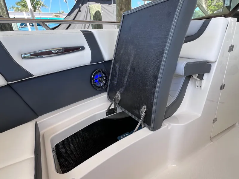 Slide: The Image of 2022 Chaparral 267 SSX OB boat interior with open storage compartment and speaker. - 34