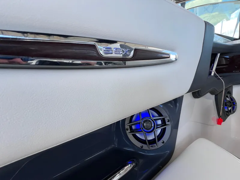 Slide: The Image of 2022 Chaparral 267 SSX OB interior with sleek design and blue-lit speakers. - 18