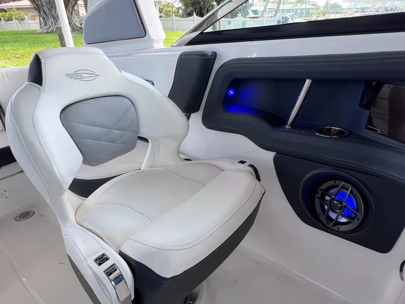 Slide: The Image of 2022 Chaparral 267 SSX OB boat interior with white seating and blue LED lighting. - 21