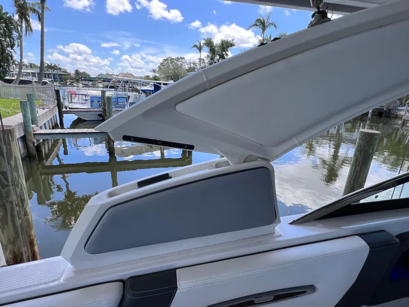 Slide: The Image of 2022 Chaparral 267 SSX OB boat with open storage compartment by a dock. - 47