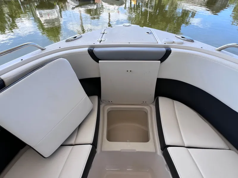 Slide: The Image of 2022 Chaparral 267 SSX OB boat interior with cushioned seating and storage compartment. - 35