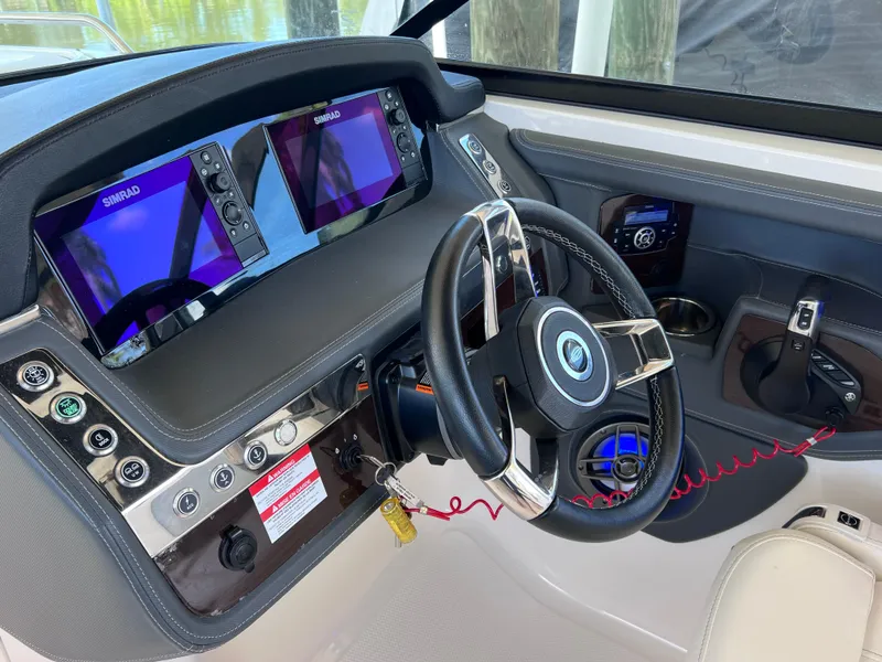 Slide: The Image of 2022 Chaparral 267 SSX OB boat dashboard with dual Simrad displays and steering wheel. - 41