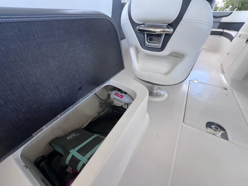 Slide: The Image of 2022 Chaparral 267 SSX OB boat interior with storage compartment and seating. - 19