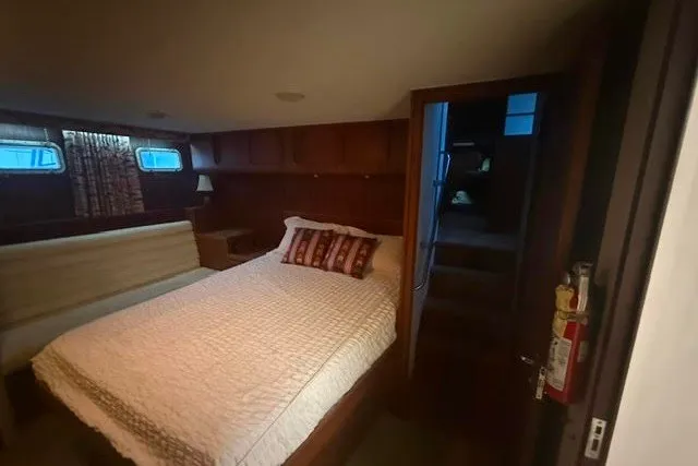 Slide: The Image of Cozy bedroom in 1987 Hatteras 72 Motor Yacht with wood paneling and soft lighting. - 13