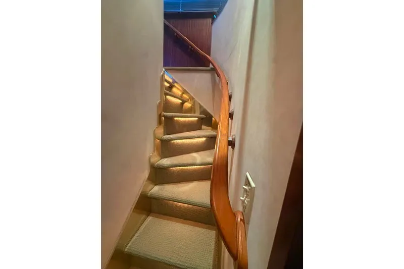Slide: The Image of Curved staircase with wooden railing inside 1987 Hatteras 72 Motor Yacht. - 12