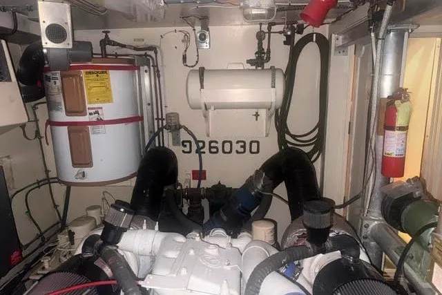Slide: The Image of Engine room of 1987 Hatteras 72 Motor Yacht with visible equipment and piping. - 14