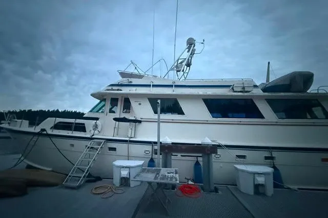 The Image of 1987 Hatteras 72 Motor Yacht docked under cloudy skies. - 1