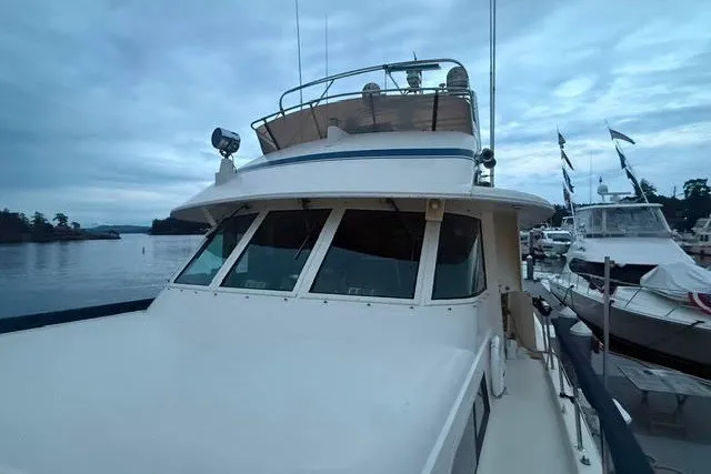 Slide: The Image of 1987 Hatteras 72 Motor Yacht docked, showcasing its sleek design and spacious deck. - 3