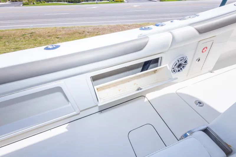 Slide: The Image of 2022 World Cat 325 CC boat interior with storage compartment and speaker. - 58
