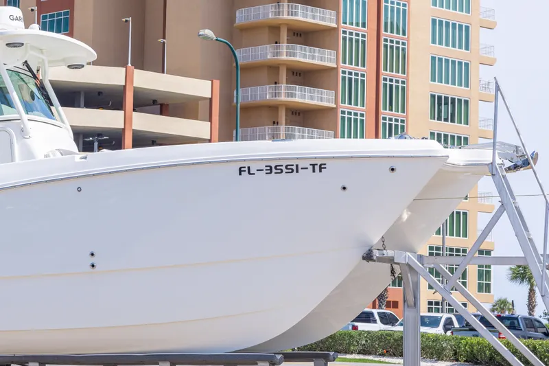 Slide: The Image of 2022 World Cat 325 CC boat on trailer near modern building. - 10