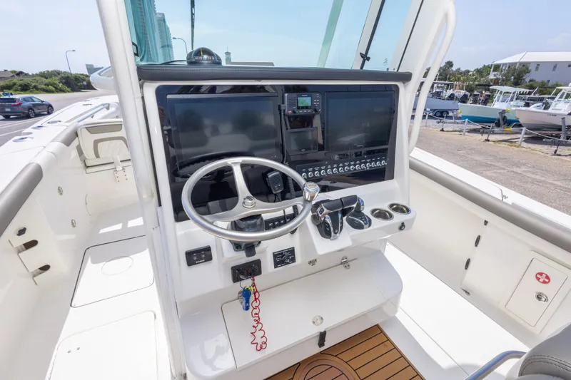 Slide: The Image of Cockpit of 2022 World Cat 325 CC boat with steering wheel and control panel. - 29