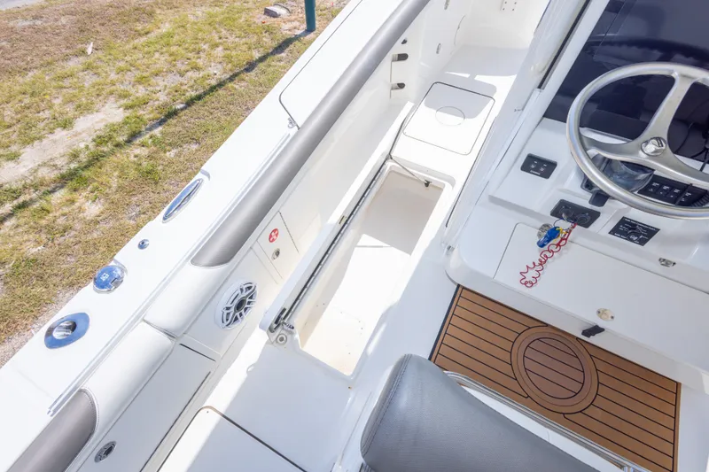 Slide: The Image of 2022 World Cat 325 CC boat interior with steering wheel and storage compartments. - 55