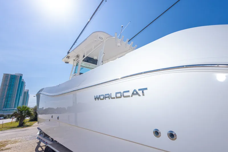 Slide: The Image of 2022 World Cat 325 CC boat under clear blue sky, modern buildings in background. - 66