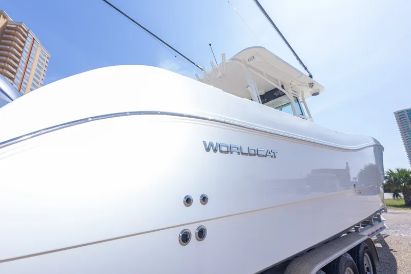 Slide: The Image of 2022 World Cat 325 CC boat, sleek design, parked outdoors under clear sky. - 16