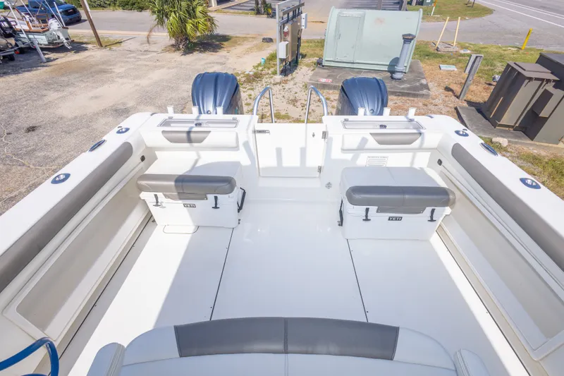 Slide: The Image of 2022 World Cat 325 CC boat deck with seating and storage, featuring dual outboard motors. - 53