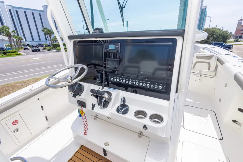 Slide: The Image of 2022 World Cat 325 CC boat dashboard with steering wheel and navigation controls. - 30