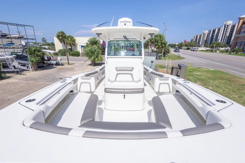 Slide: The Image of 2022 World Cat 325 CC boat with spacious seating, docked near a road and buildings. - 37