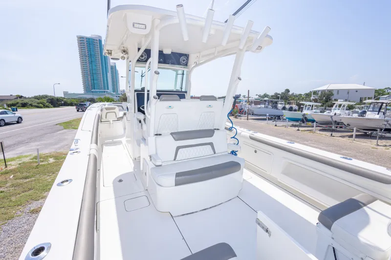 Slide: The Image of 2022 World Cat 325 CC boat interior with seating, docked near modern buildings. - 24